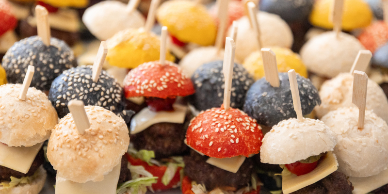 Viele bunte Mini-Burger sind auf einem Tablett arangiert.