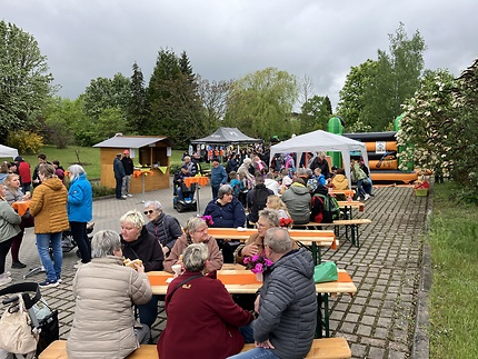 Die Besucher des Frühlingsfestes sitzen an Tischen und genießen Essen und Trinken.