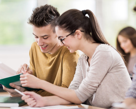 Lehrerinnen und Lehrer der Berufsschule stehend im Klassenzimmer