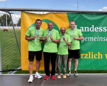 4 Männer zeigen ihrer Medaille bei der Siegerehrung