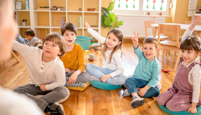 Aktive Vorschulkinder interagieren mit ihrem Lehrer.