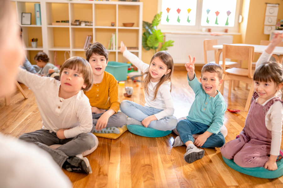 Aktive Vorschulkinder interagieren mit ihrem Lehrer.