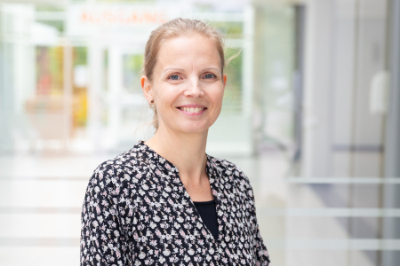 Eine Frau steht am Eingang des KBBW und lächelt freundlich.