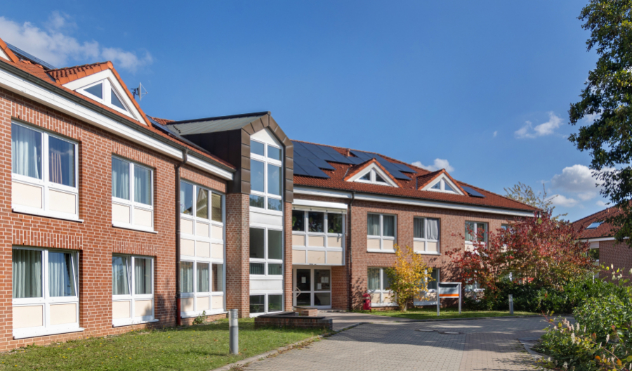 Wohnheim mit Fenstern und Eingangsbereich, begrünter Zugang