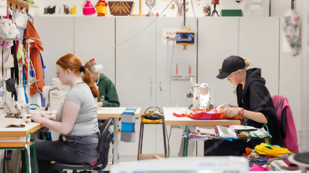 Auszubildende arbeiten an N&auml;hmaschinen und verarbeiten Stoffe im textilen Ausbildungsbereich des Berufsbildungswerks Hettstedt.