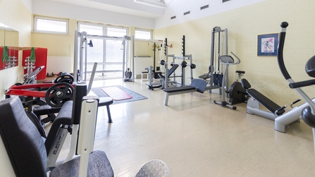 Menschenleerer Trainingsraum mit Fitness- und Kraftger&auml;ten zur sportlichen F&ouml;rderung