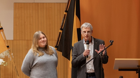 Schulleiter der Berufsschule der KBBW und Sch&uuml;lerin auf der B&uuml;hne
