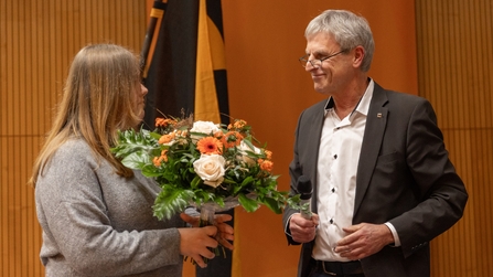 Schulleiter der Berufsschule der KBBW &uuml;bergibt Blumenstrau&szlig; an Sch&uuml;lerin