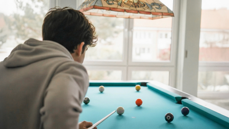 Jugendlicher spielt Billard 