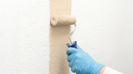 Nahaufnahme der Auszubildenden beim Bemalen der Wand
