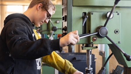 Auszubildender im Metallbereich bedient eine Maschine